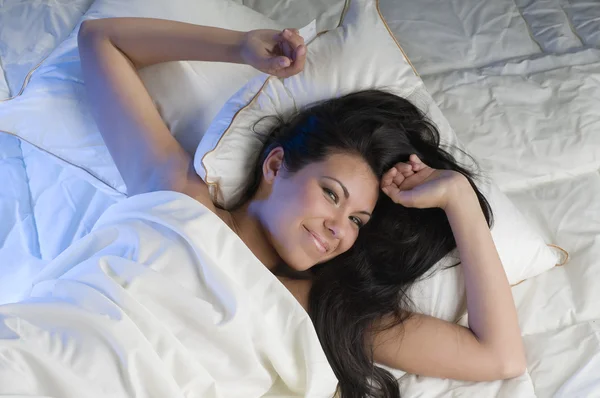 目を覚ますベッドで若くて美しいブルネット — ストック写真