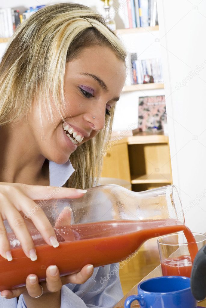 an cute young woman just waked up and drinking orange juice during her morning breakfast