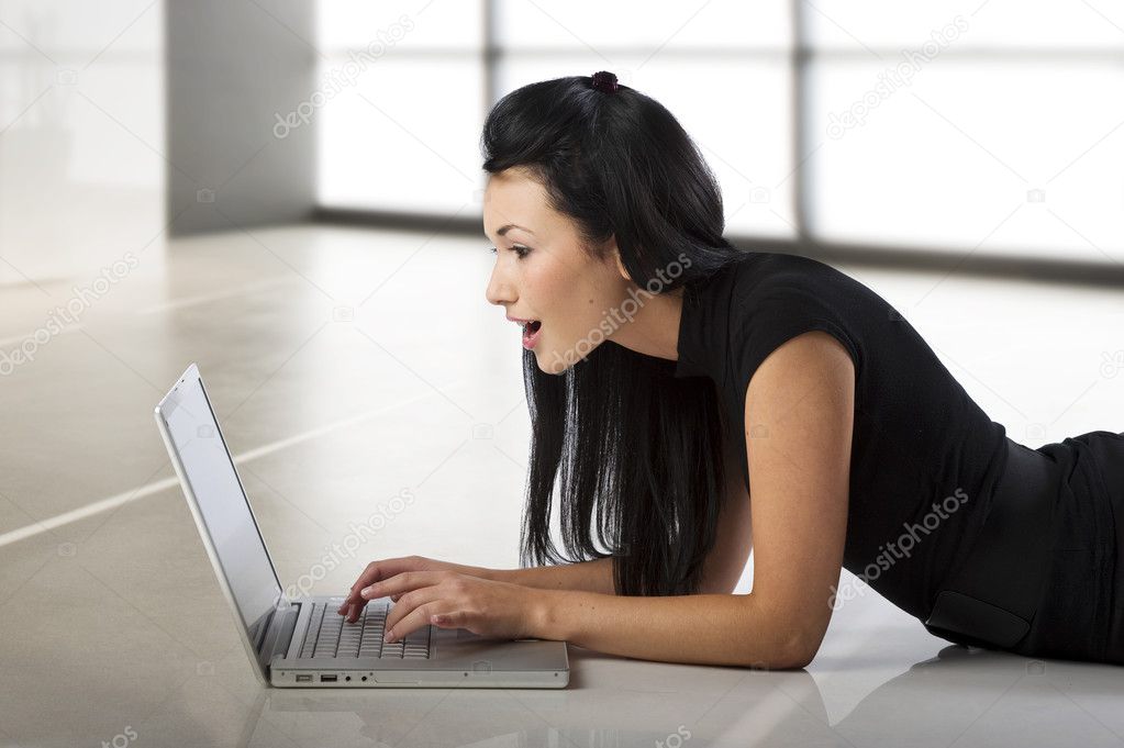 beautiful young oriental woman looking at the laptop with a surprised expression