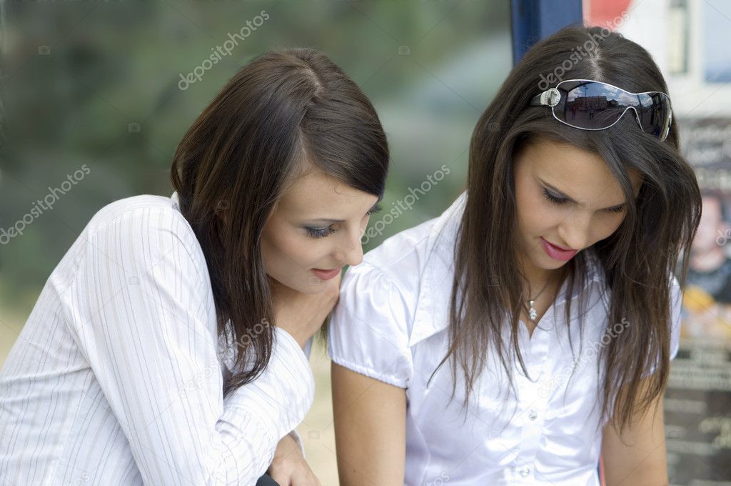 young women talking togheter and watching something down