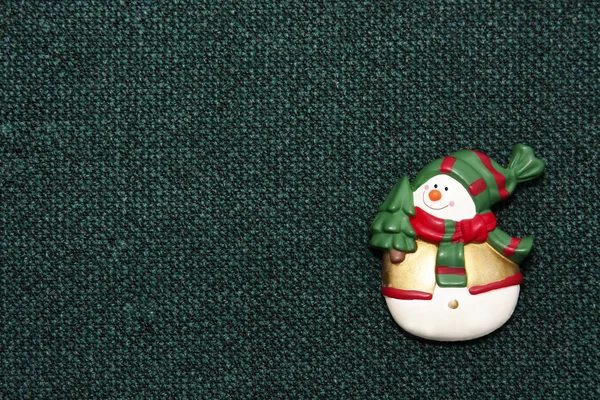 Різдвяний сніговик на зеленому тканинному фоні — стокове фото