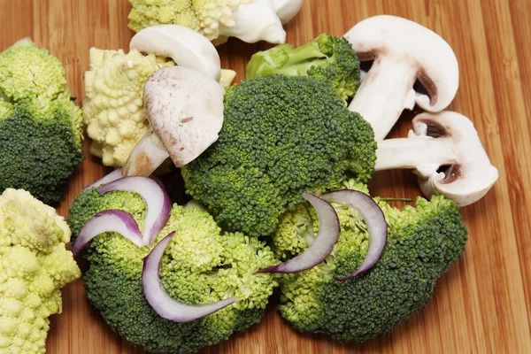 stock image Onion, broccoli, cauliflower mushrooms on wooden surface