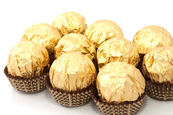 Chocolaatjes Een Papper Goud Folie Witte Achtergrond — Stockfoto