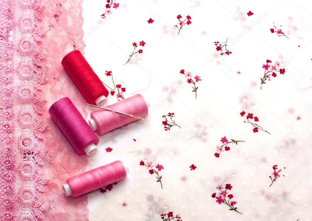 Pink spools of thread on a floral fabric