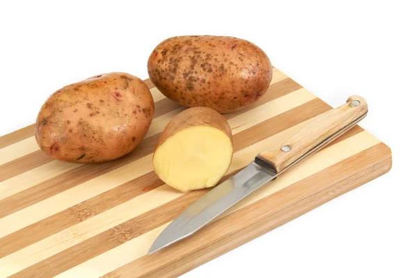 Bulwy ziemniaków surowych leżącego na pokładzie cięcia — Zdjęcie stockowe