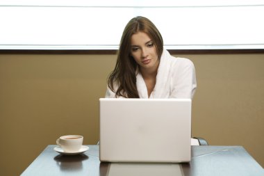 Young woman looks at her laptop computer clipart