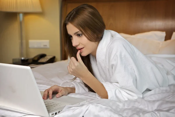 Mulher morena bonita olhando para um laptop — Fotografia de Stock