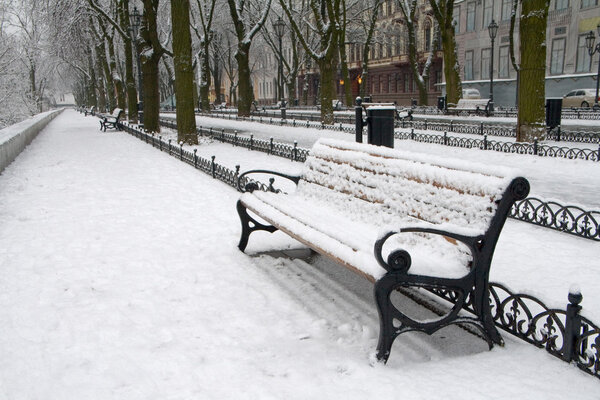 Snow on bench in park of winter.