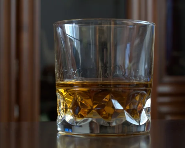 The glass with whisky on table — Stock Photo, Image