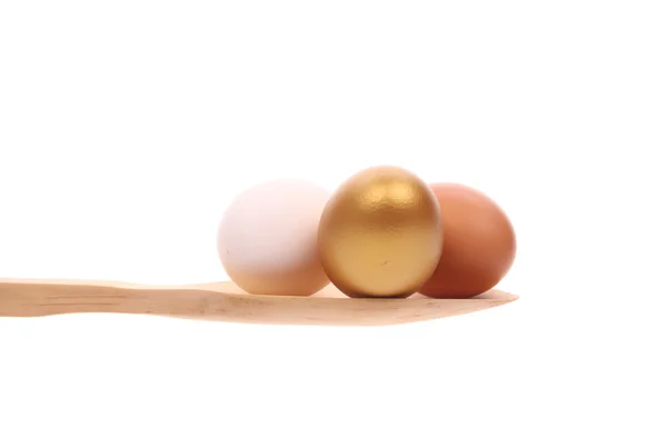 Uova su un cucchiaio di legno isolato su uno sfondo bianco — Foto Stock