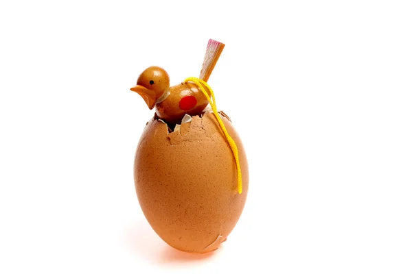 Little wooden chicken coming out of an egg — Stock Photo, Image