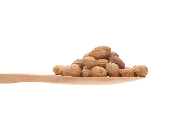 Erdnüsse auf einem Holzlöffel isoliert auf weißem Hintergrund — Stockfoto