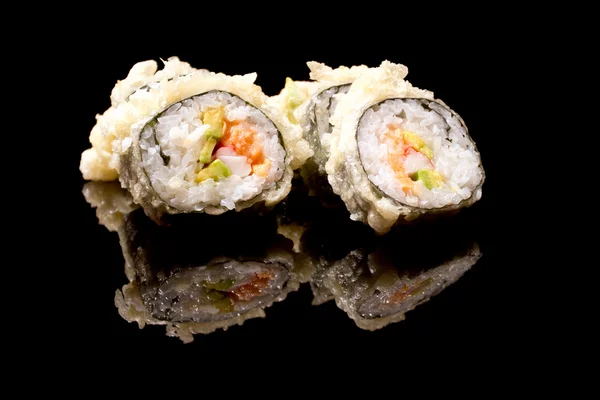 Rolki sushi zorganizowany przez czarny — Zdjęcie stockowe