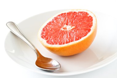 Fresh half of grapefruit on plate with spoon isolated on white clipart