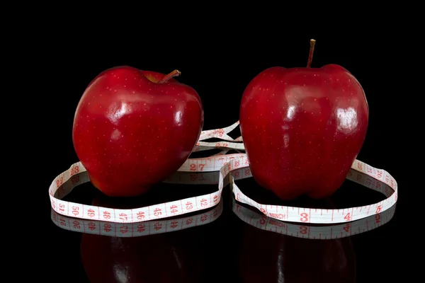 Jabłka z centymetr na czarnym tle — Zdjęcie stockowe