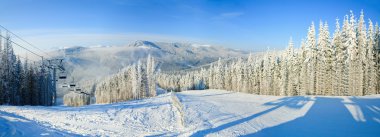 Winter mountain landscape with ski lift and skiing slope. clipart