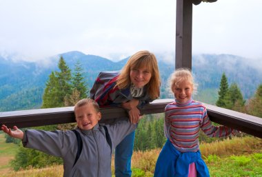 Family on wooden mountain cottage porch clipart