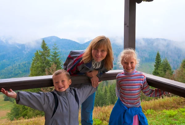Família no alpendre de madeira da cabana da montanha — Fotografia de Stock