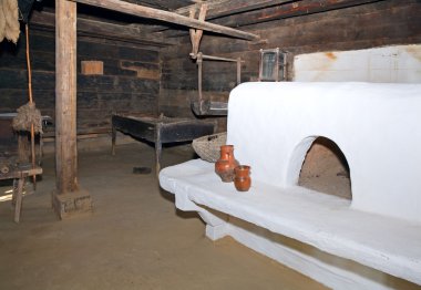 Historical peasant dwelling interior with stove clipart