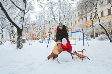 Mutlu aile (küçük erkek ve kız annesiyle) kış Şehir Parkı