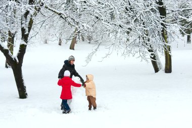 Mutlu aile (küçük erkek ve kız annesiyle) kış Şehir Parkı