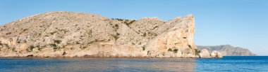 Summer rocky coastline and military base on rock top (Alchak Cape; Sudak Town environs, Crimea, Ukraine). Three shots stitch image. clipart