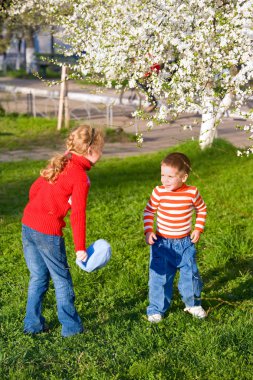 Happy small children in spring recreation ground clipart