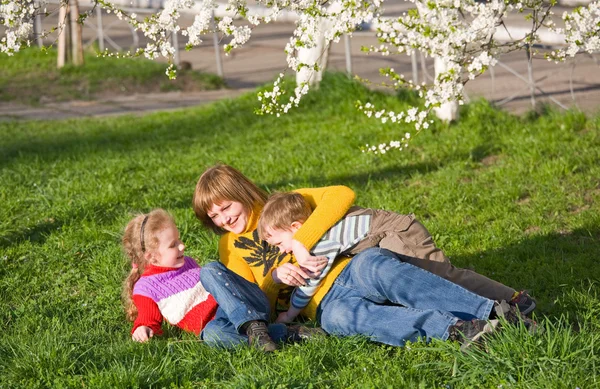 春のレクリエーションの地面に小さな子供を持つ幸せな母親 — ストック写真