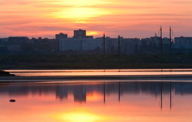 gün batımı sky (scholkino, Kırım, Ukrayna) kasaba ve bunu yukarıda göl yansıması