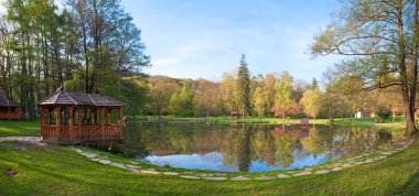 Beautiful spring lake and wooden belvedere in the park. Two shots stitch image. clipart