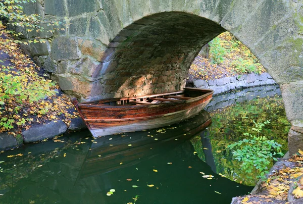 用反射的树木和船下拱在秋天公园池塘水表面 — 图库照片