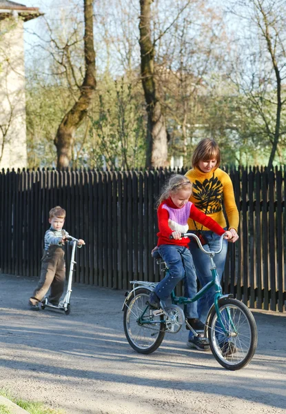 母は車で自転車やスクーターを子供たちを教える — ストック写真