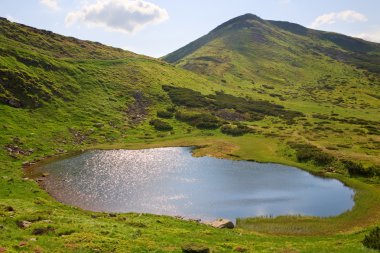 Alpine lake Nesamovyte on summer mountains clipart