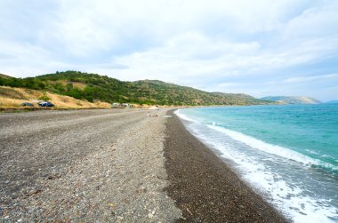 güzel yaz kıyı şeridi, Aile altında gölge şemsiye ve kamp Plajı (Kırım, Ukrayna).