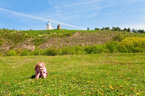 Small girl on spring blossoming field — Stock Photo, Image