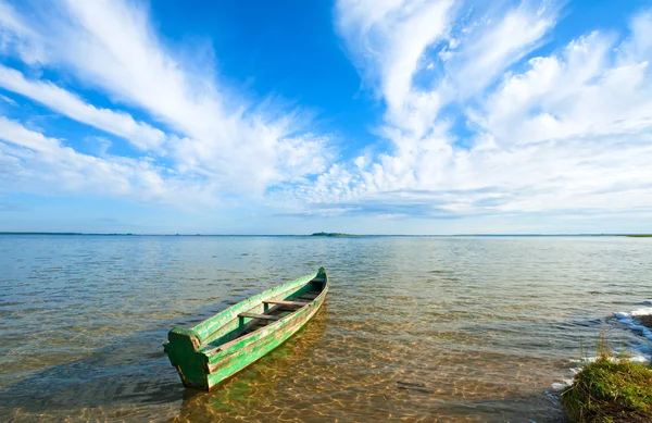 Лодка на берегу летнего озера — стоковое фото