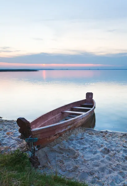夏の湖の海岸の近くのボートと夕日 — ストック写真