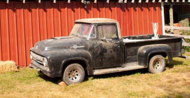 Old pickup truck parked by a barn in Idaho clipart