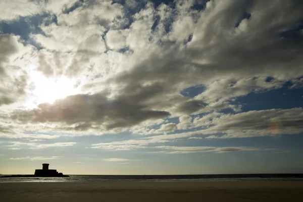 Яркое солнце и облака над пляжем — стоковое фото