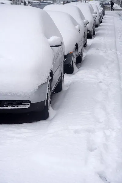 Припаркованные машины на снежной улице — стоковое фото