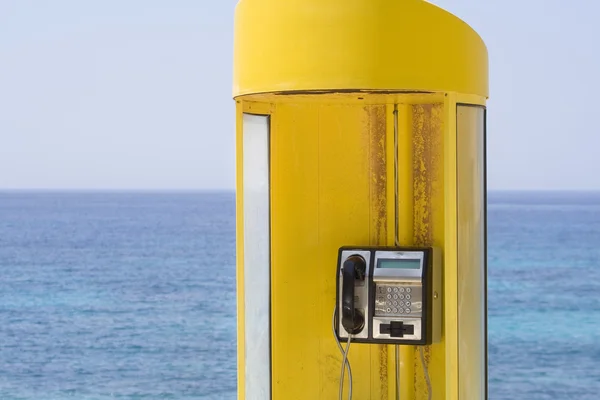 Yellow phone, blue sea — Stock Photo, Image