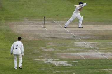 Scene at first-class cricket match as batsman plays a ball clipart