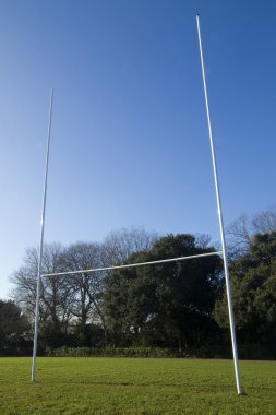 Sun glinting on rugby posts on local pitch clipart