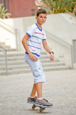 Boy doing stunts on a skateboard in afternoon sun . clipart