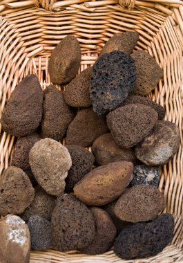 Volcanic pumice for sale in a wicker basket. clipart