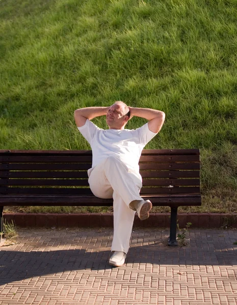 Stock image Man resting on a bench in a summer day.