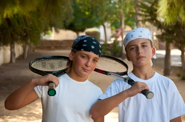 iki genç erkek tenis raketi ile .