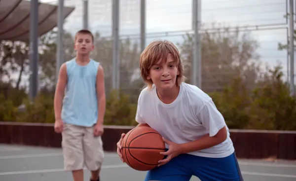 Kids play basketball in a school. — Stock Photo, Image