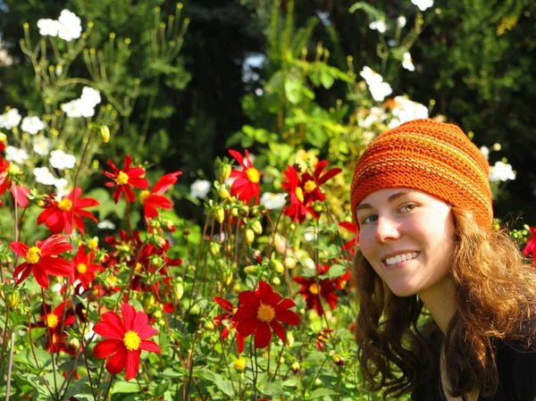 Ung kvinna läckerheter i en blomsterträdgård. — Stockfoto