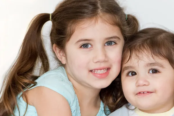 Cute Hispanic-American sisters pose and smile for a portrait. — Stock Photo, Image